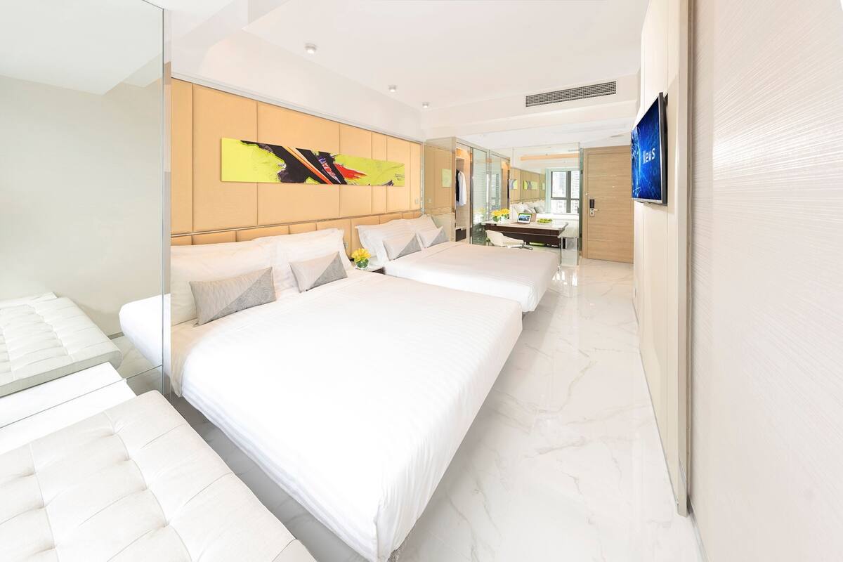 Una habitación de hotel moderna con una cama grande, un sofá independiente, un escritorio y un baño.