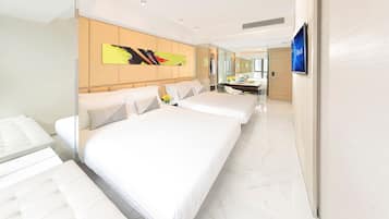 Une chambre d’hôtel moderne dotée d’un grand lit, d’un canapé séparé, d’un bureau et d’une salle de bain.