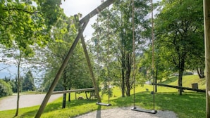 A swing set in a park with a dirt path and grassy areas. - Le Bochate by Interhome (Les Bottières)