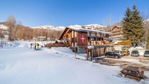 A wooden building with a red cross, a ski lift, and a snowy mountain backdrop. - Le Bochate by Interhome (Les Bottières)