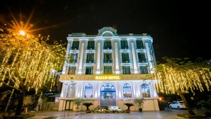 Et hotel med en klassisk facade, store vinduer og et skilt med teksten "HALLO HOTEL".