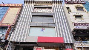 A building with multiple signs, including 'Shubham Jewellers' and 'Shubham Jewellers' with a logo. - OYO 63371 R Square Stay (Hyderabad)