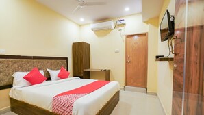 A hotel room with a bed, a wardrobe, a TV, and an air conditioning unit. - OYO 63371 R Square Stay (Hyderabad)
