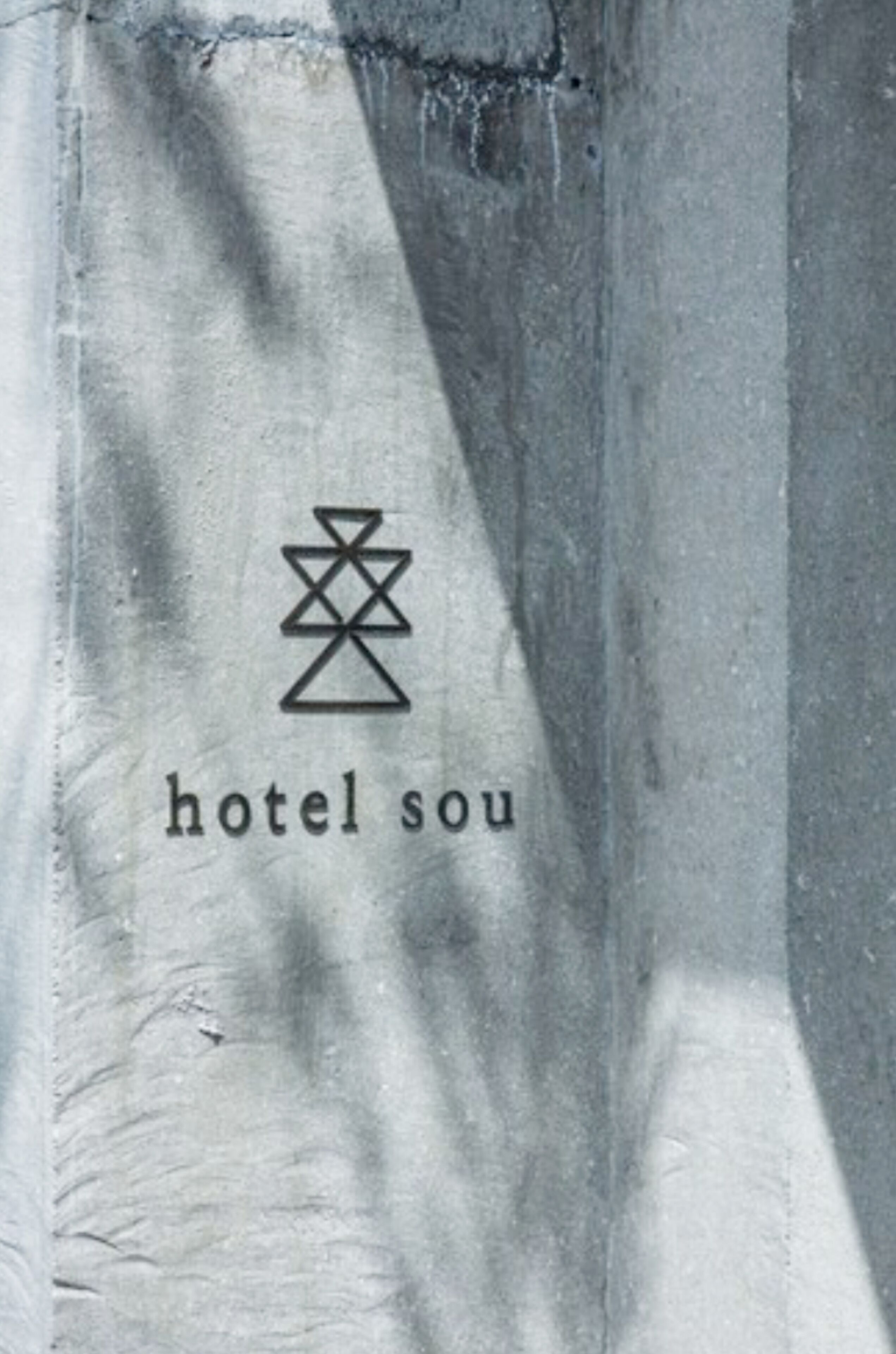 Pared de concreto con un logotipo y el texto 'hotel sou'.