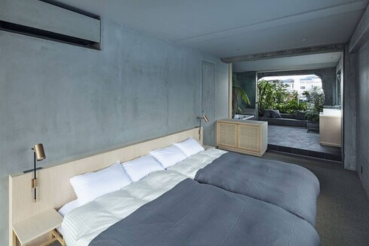 A modern bedroom with a large bed, a nightstand, and a built-in cabinet.
