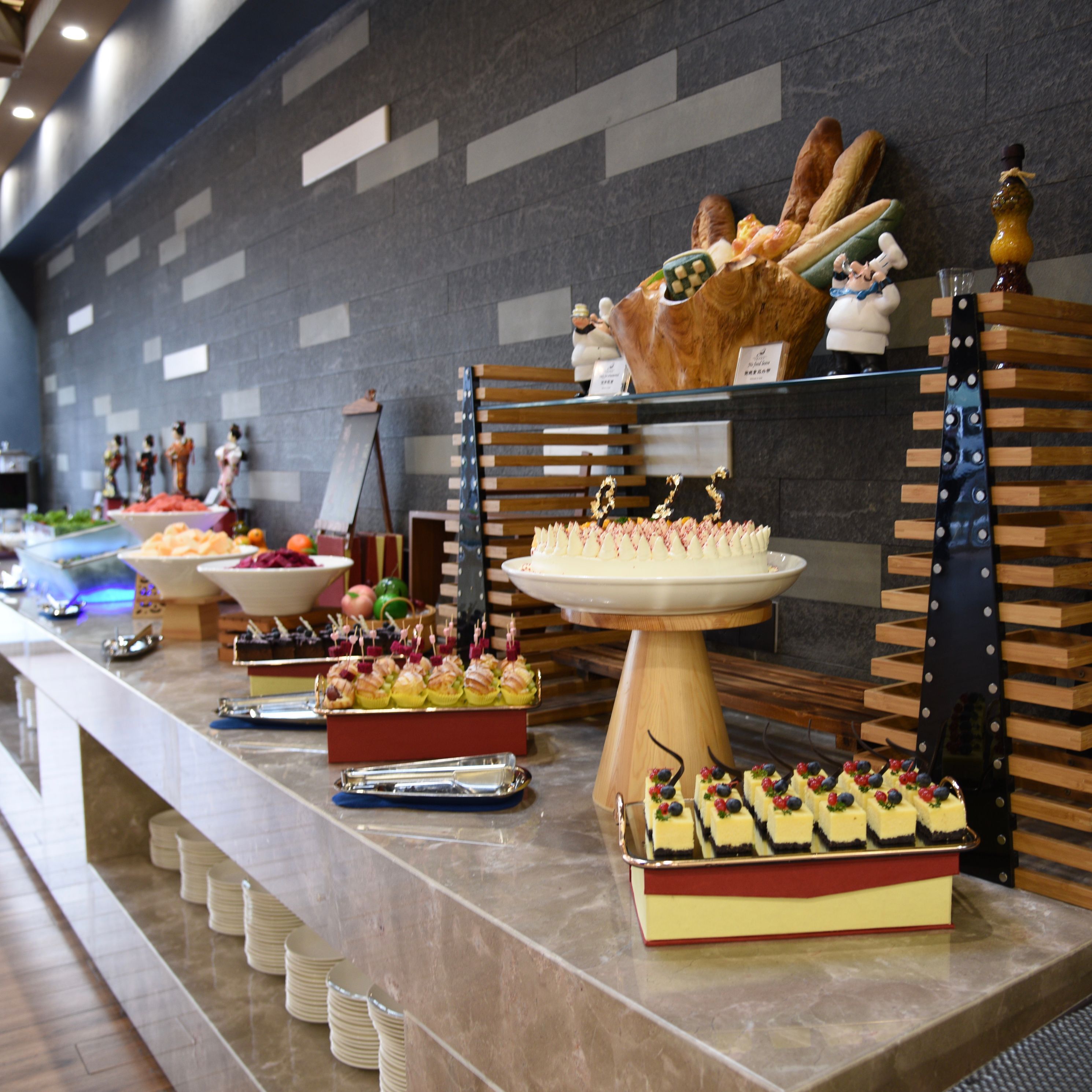 A buffet with various food items and a display of pastries.
