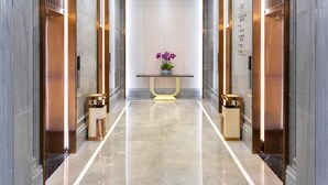 A modern hallway with a marble floor, a central reception desk, and a decorative ceiling. - Lily's Hotel Hangzhou (Hangzhou)