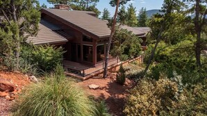 A cabin with a covered porch, surrounded by trees and a clear sky. - Home Surrounded by Lush Landscape + Mtn Views! (Sedona)