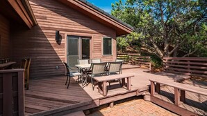 A wooden deck with outdoor furniture, a patio table, and a wooden fence. - Home Surrounded by Lush Landscape + Mtn Views! (Sedona)