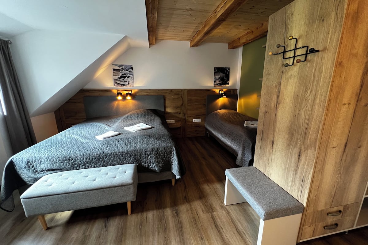 A cozy bedroom with a loft bed, a bench, and wooden accents.