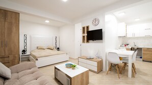 A modern, well-lit bedroom with a bed, bedside table, and a small desk with a chair. - Apartmani Mia (Sveti Stefan)