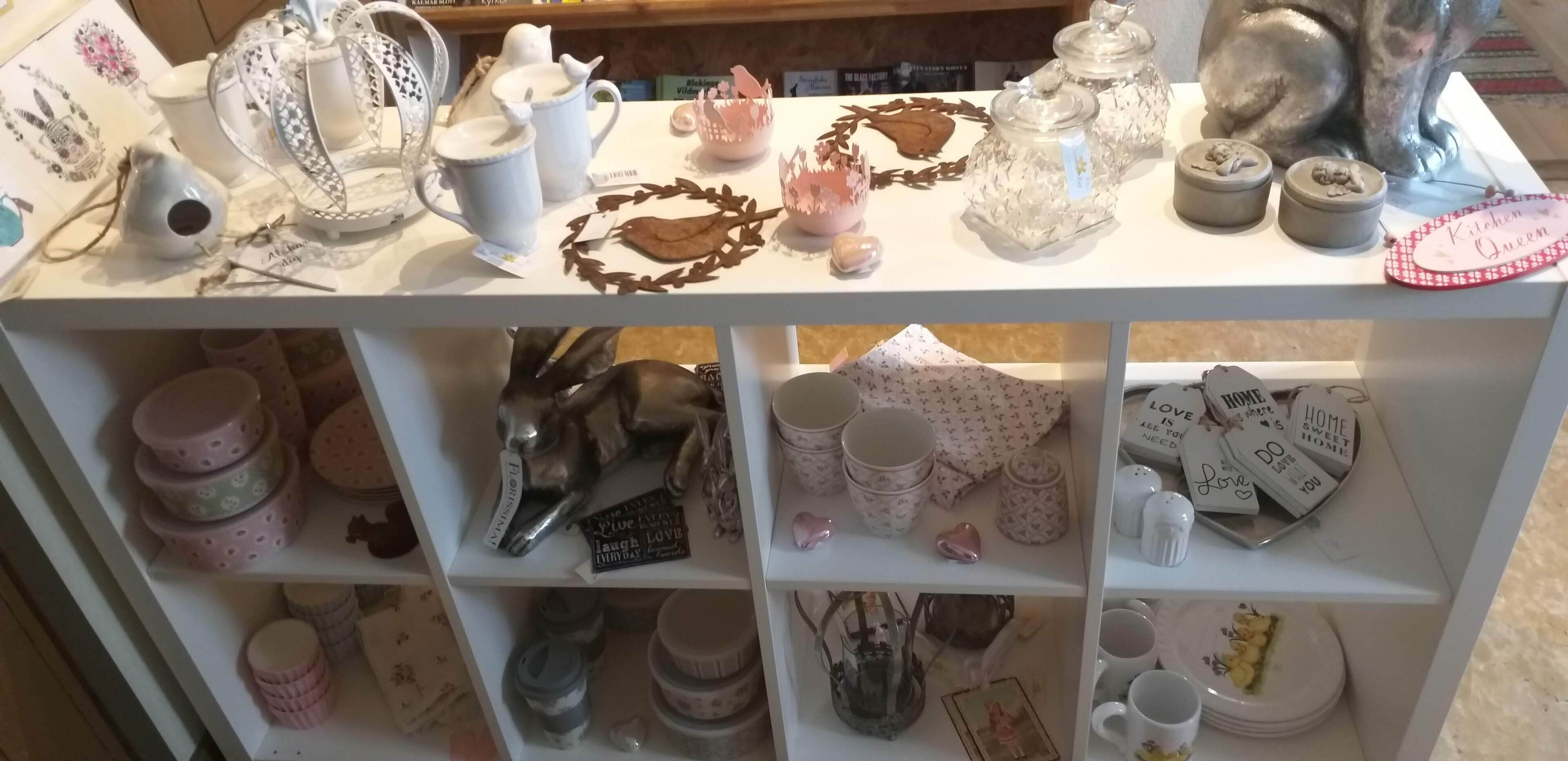 A display of kitchenware and decorative items on shelves.