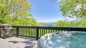 A hot tub on a wooden deck with a scenic view of mountains and trees. - 🏔 Awesome View Cabin – Stunning Views - Hot Tub - Pet Friendly - Game Loft. (Maggie Valley)