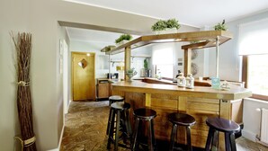 A kitchen with a wooden island, bar stools, and a large window.