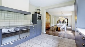 A modern kitchen with granite countertops, built-in ovens, and a central island.