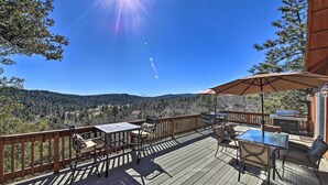 En uteplats med utemöbler, en grill och utsikt över bergen.