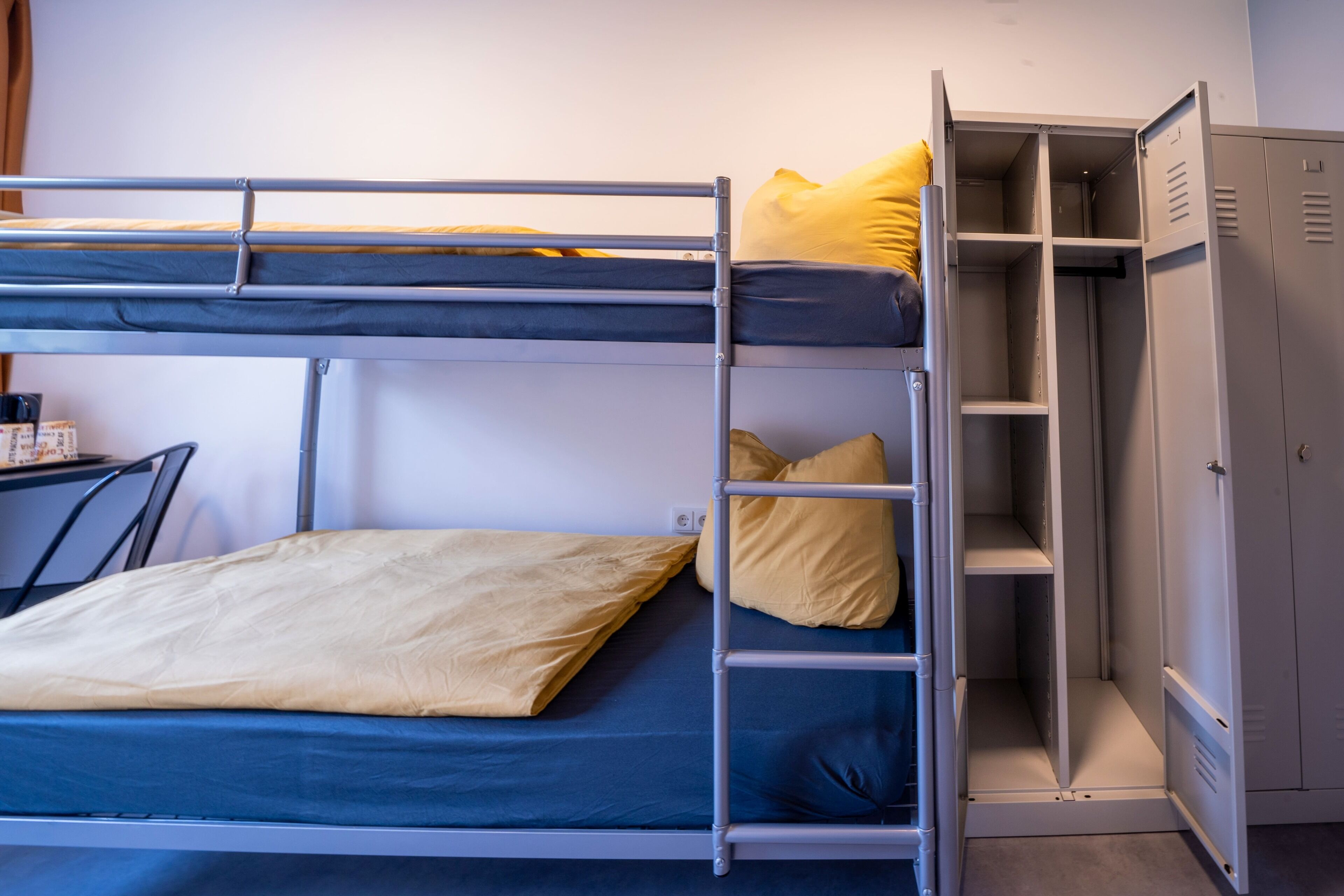 Ein Etagenbett mit Schreibtisch und Stauraumschränken.