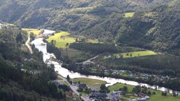 A river flowing through a valley with houses and greenery.