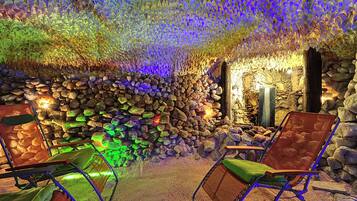 A cave-like interior with seating and a stone wall.