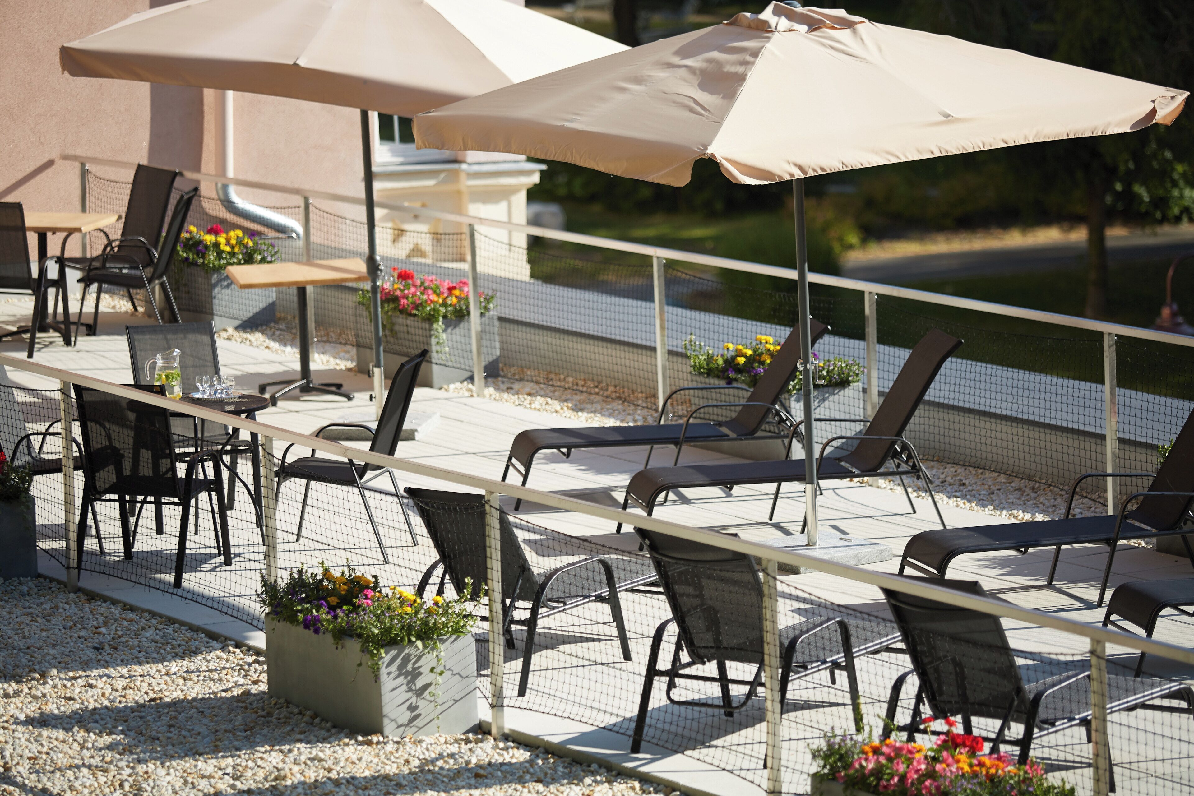 An outdoor seating area with tables, chairs, and umbrellas.