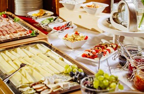 A buffet with various food items including cheese, fruits, and jams. - Landhaus Albert Murr (Sankt Anton am Arlberg)