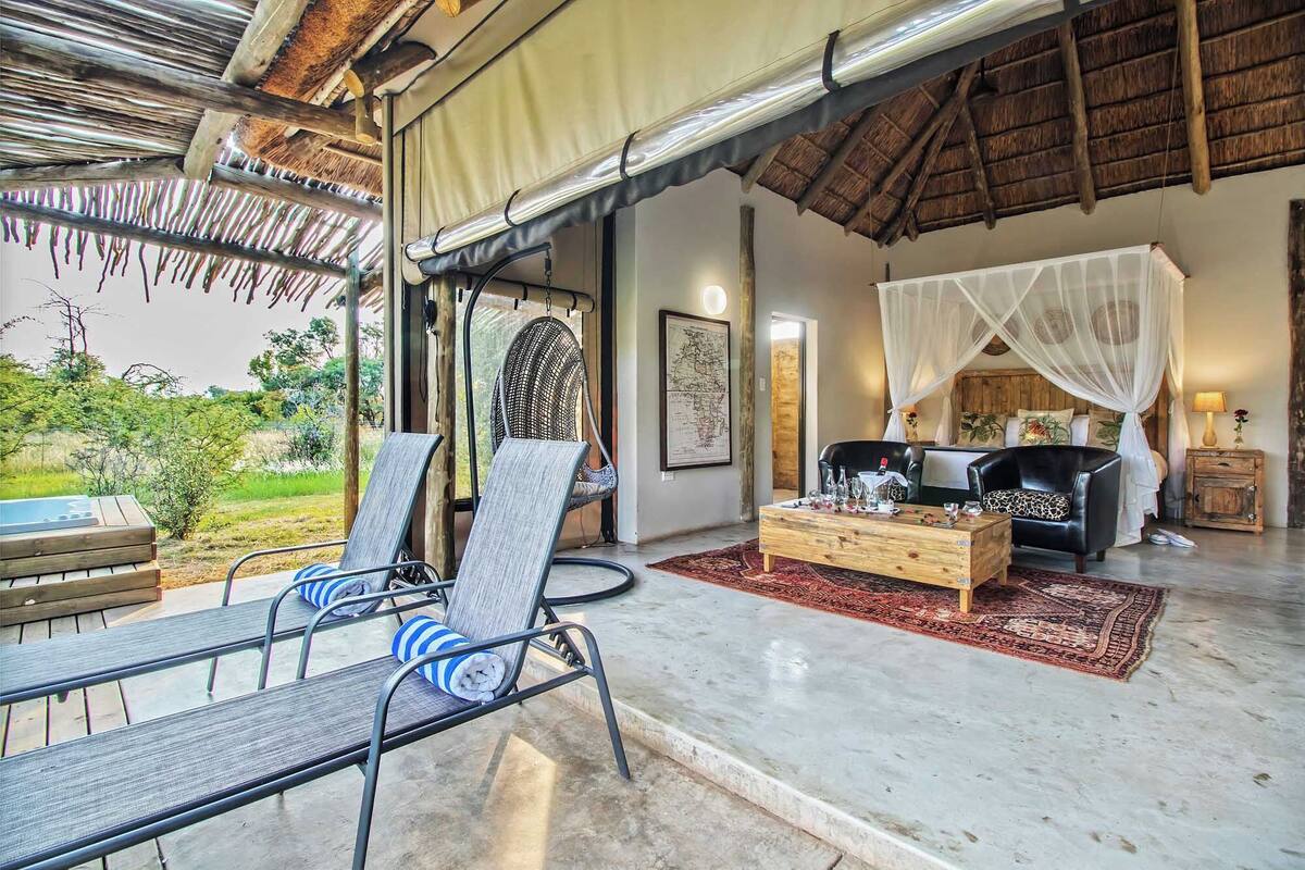 A spacious living area with a sofa, chairs, and a coffee table, featuring a view of the outdoors.