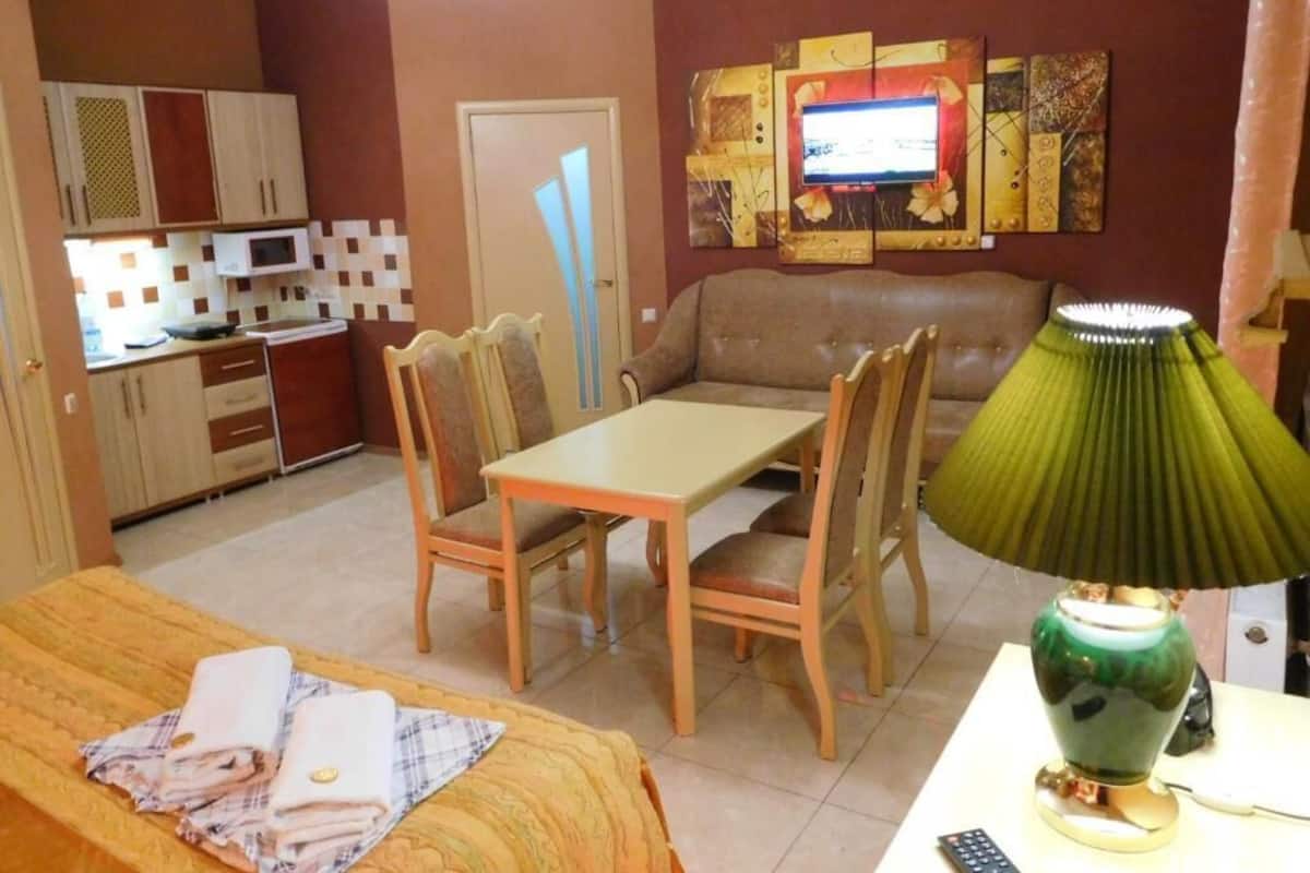 A compact living space with a kitchenette, a dining area, and a sofa.