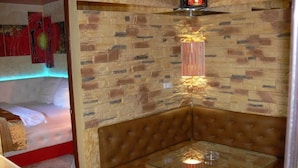 A corner seating area with a glass table and a brown cushioned bench. - Apart Hotel Dom (Odesa)