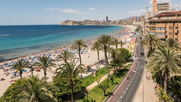 A coastal cityscape with a beach, palm trees, and a road with vehicles. - Flats Friends Atlantida 1 bedroom (Benidorm)