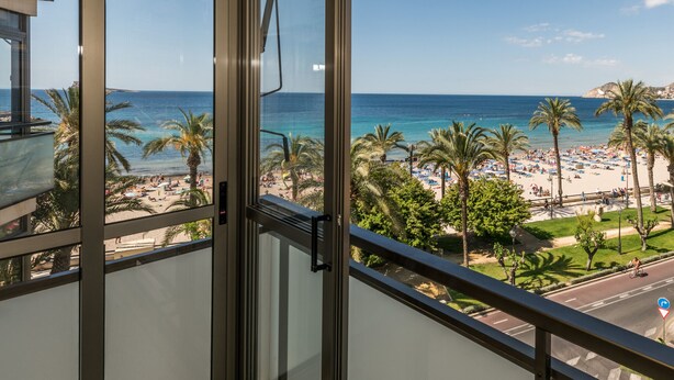 A balcony with a view of a beach, palm trees, and a clear sky. - Flats Friends Atlantida Corner Studio (Benidorm)