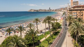 A coastal cityscape with a beach, palm trees, and a road with vehicles. - Flats Friends Atlantida Corner Studio (Benidorm)