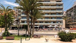 A multi-story hotel with balconies, outdoor seating, and palm trees. - Flats Friends Atlantida Corner Studio (Benidorm)