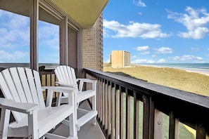 Enjoy the ocean view from this balcony with two Adirondack chairs.