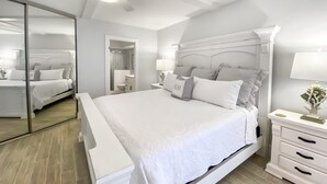 Una camera da letto moderna con un letto grande, comodini, uno specchio e una ventola a soffitto.