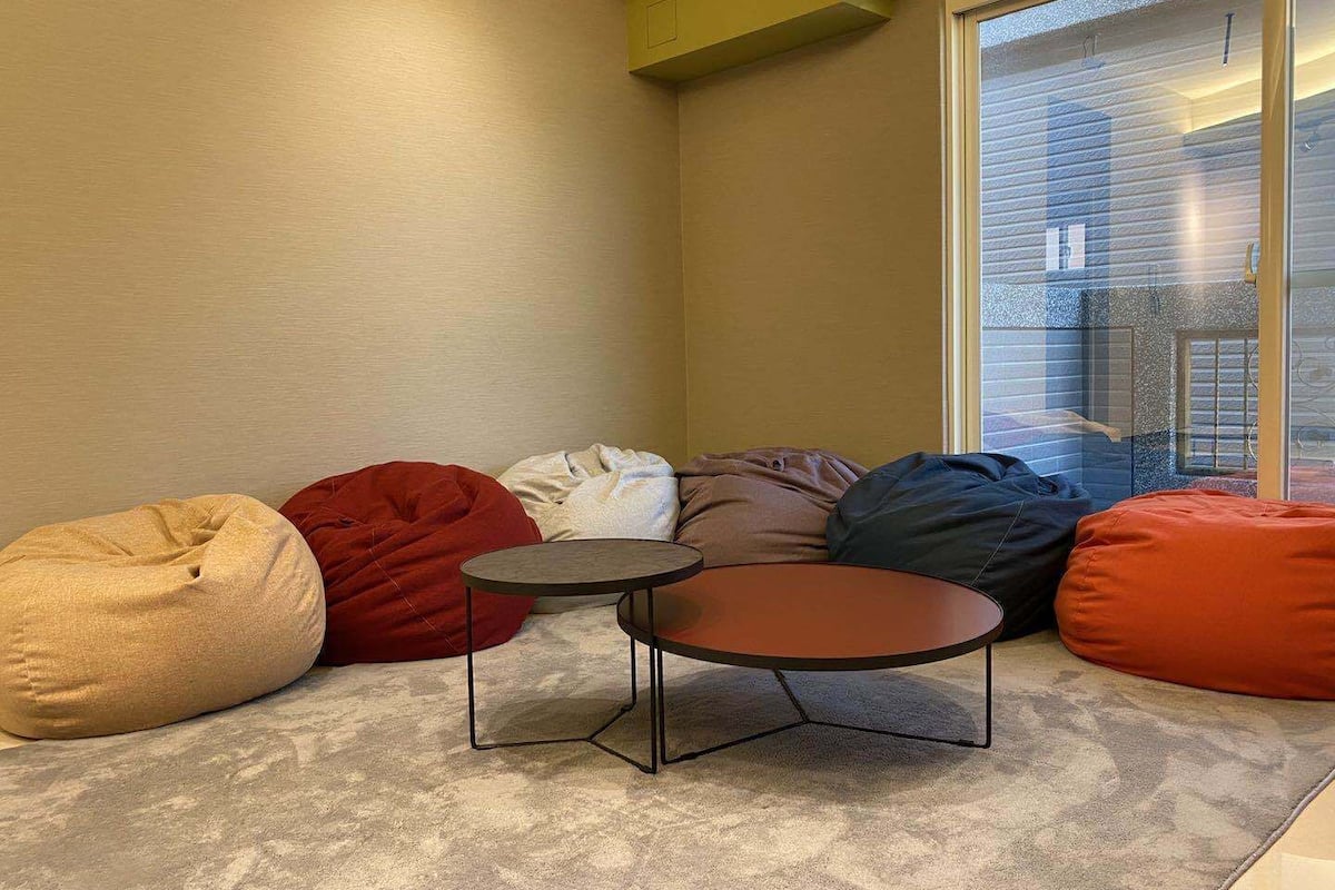 Un rincón con asientos, una mesa redonda y sillones de mimbre.