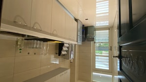 Una cocina moderna con gabinetes blancos, un refrigerador de acero inoxidable y un horno empotrado.