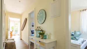 Una camera con un letto, un comodino con una sveglia, un cesto di fiori e vista sull'esterno.