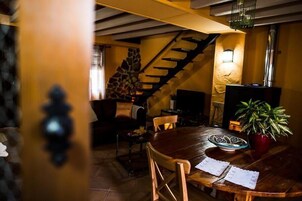 A cozy dining area with a wooden table, chairs, a decorative bowl, and a potted plant.