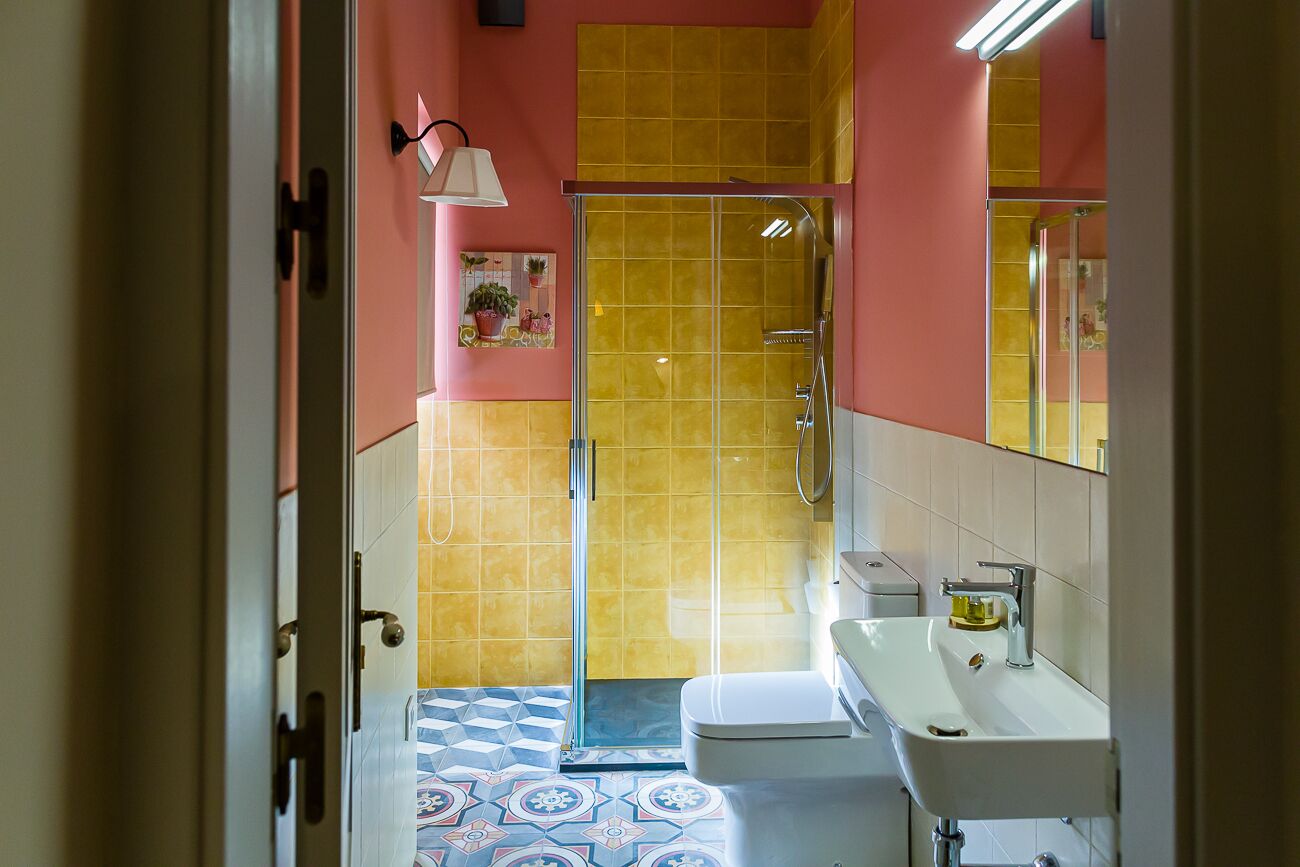 Et badeværelse med bruser, toilet og håndvask.