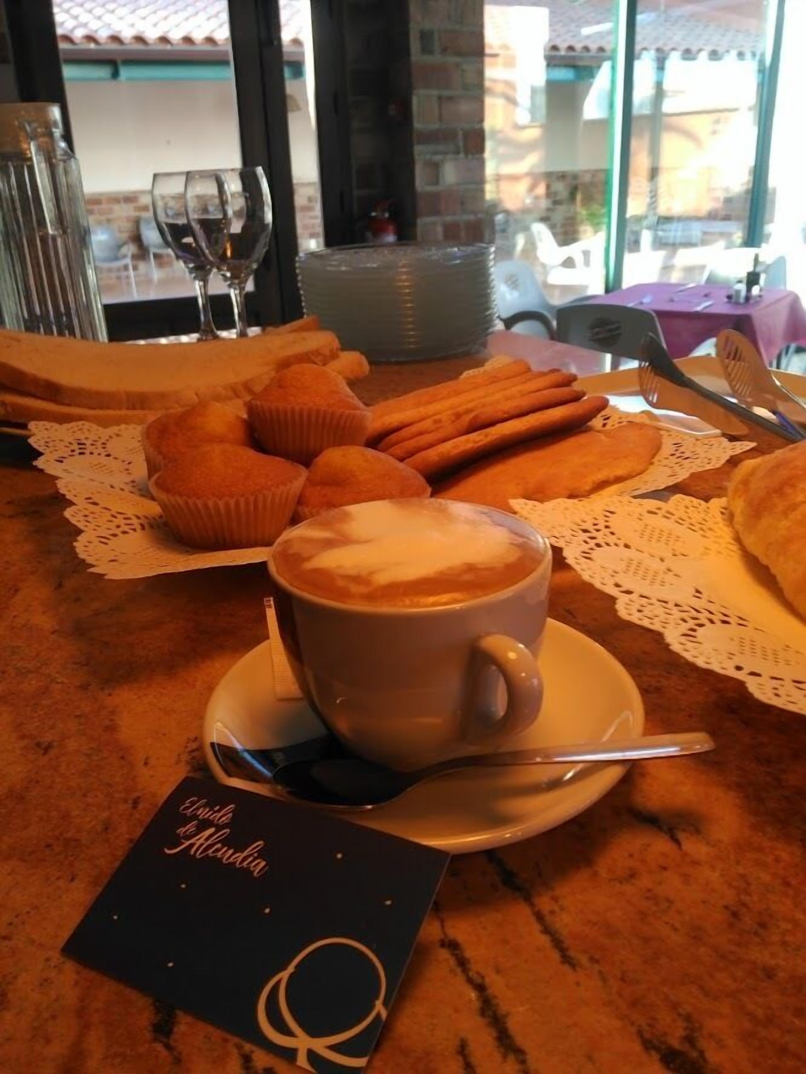 Une table avec une tasse de café, des pâtisseries et un menu.