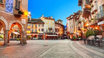 A historic square with traditional architecture, outdoor seating, and a clear sky.