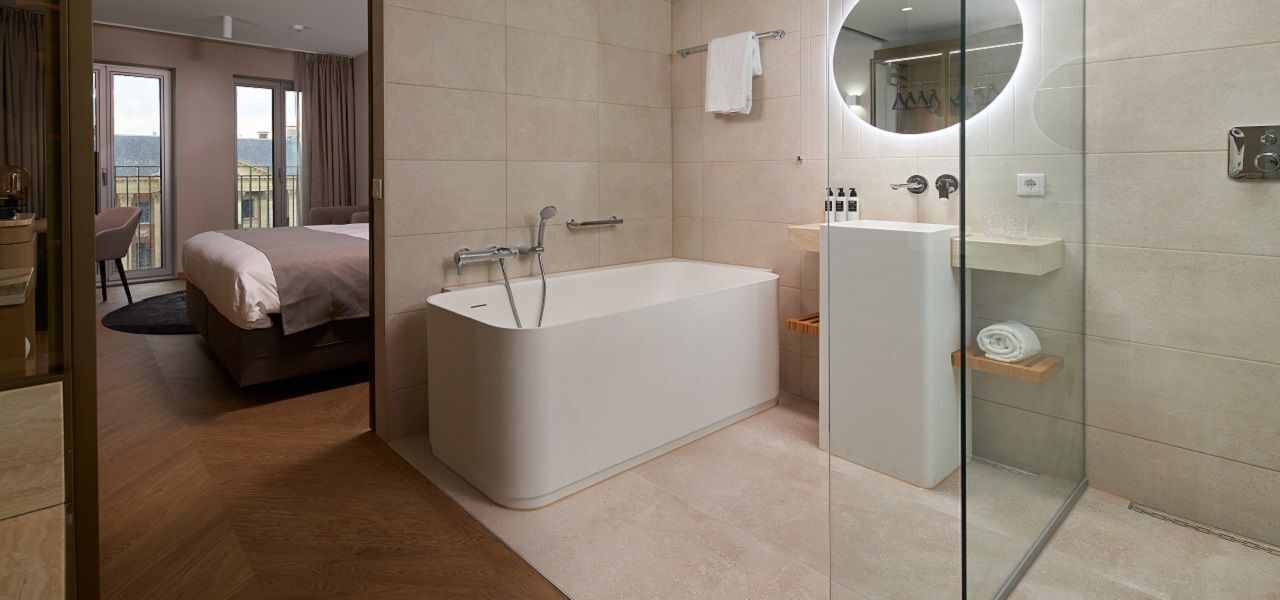 A modern bathroom with a bathtub, a glass shower enclosure, and a sink.
