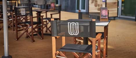 A wooden table and chairs with a logo on the backrest.
