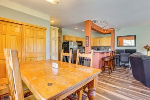 Une cuisine spacieuse avec des meubles de rangement en bois, une table à manger et un coin salon confortable.
