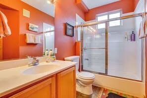 Une salle de bain avec un grand lavabo, des toilettes et une douche à parois de verre.