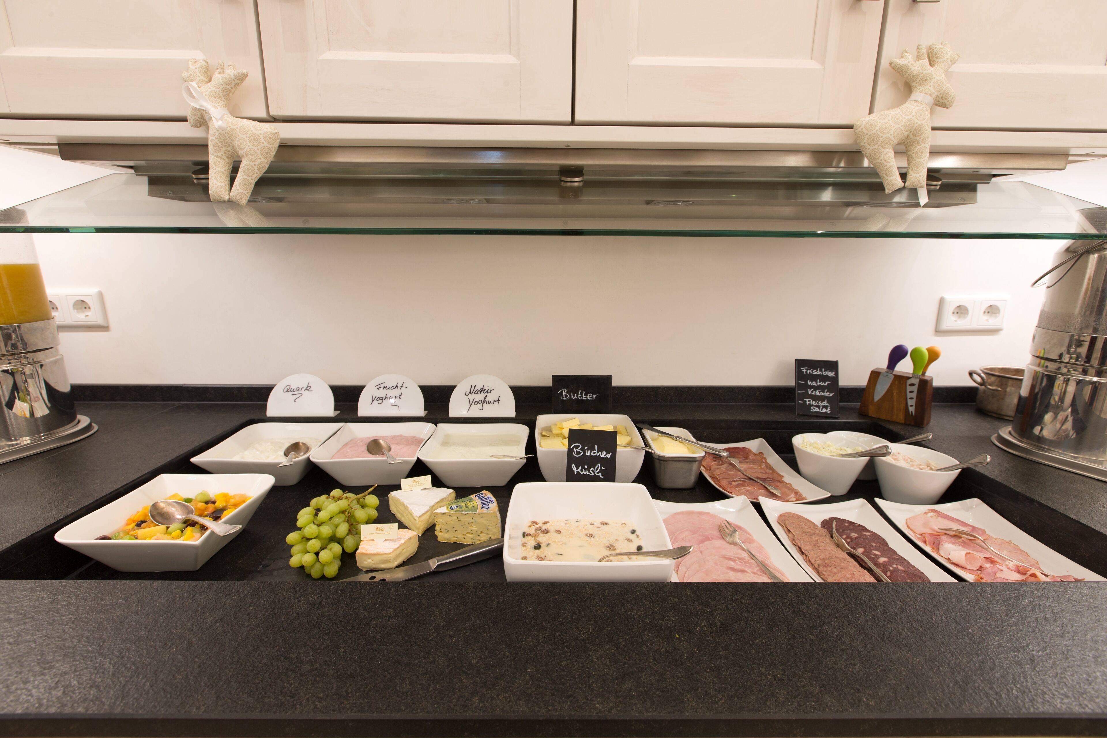 A buffet with various food items and labels.