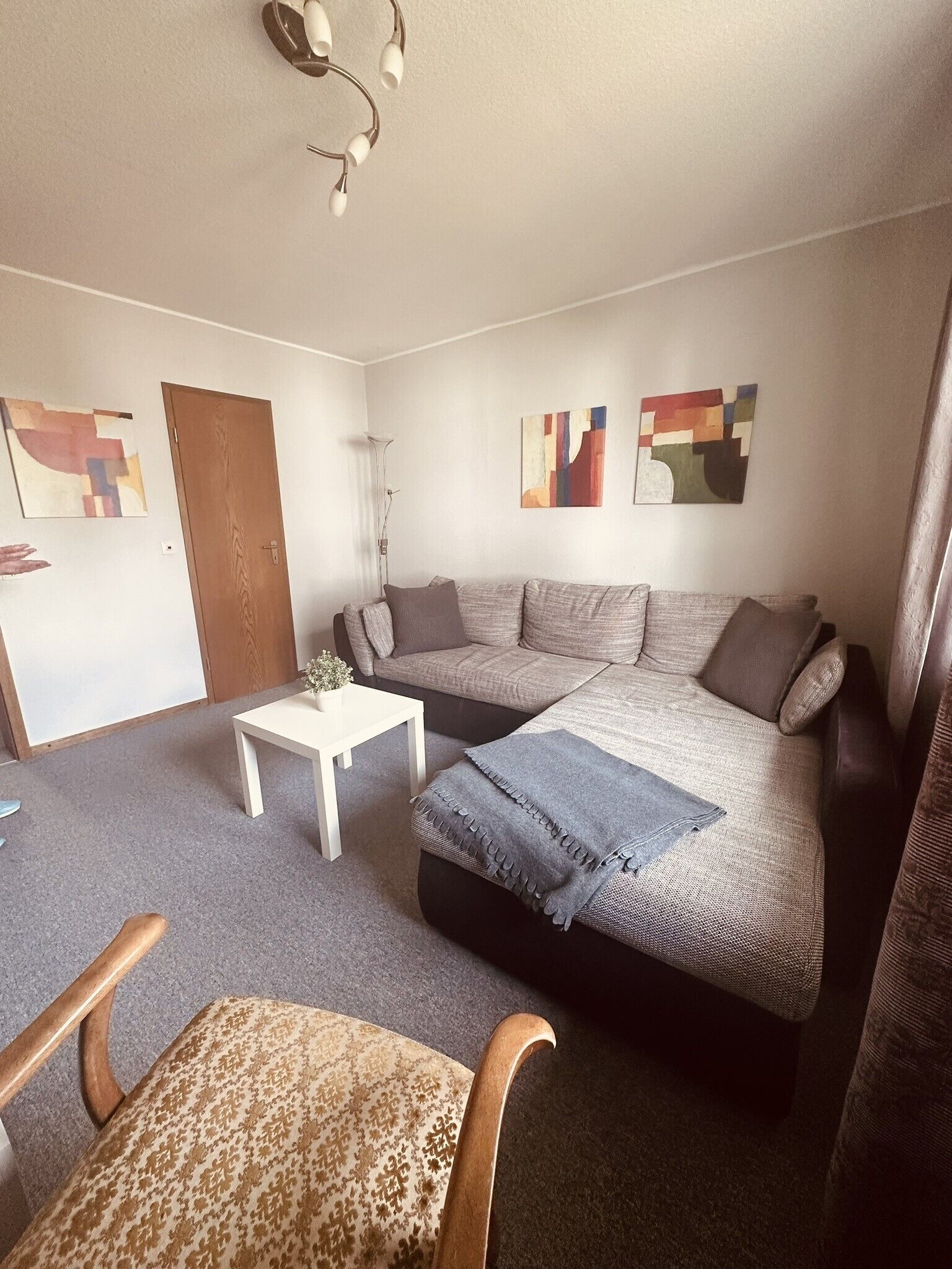 Una sala de estar acogedora con un sofá, una mesa de centro y un sillón estampado.