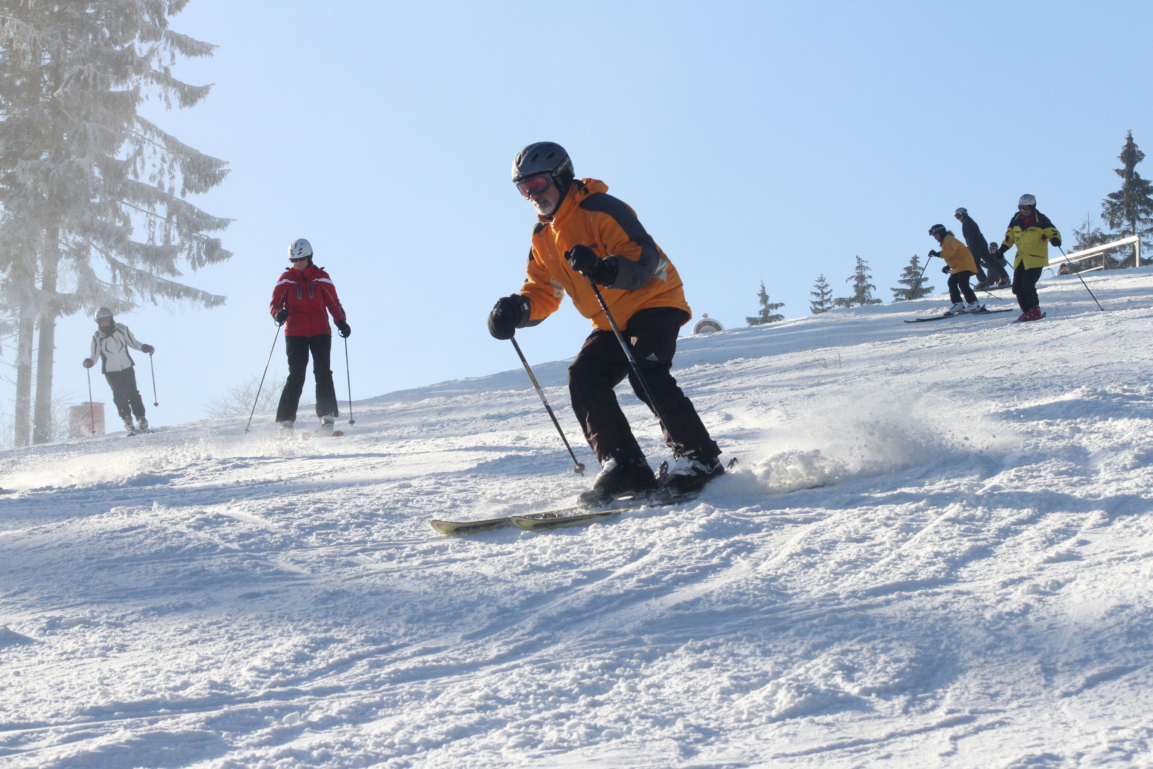 A snowy ski slope with skiers.