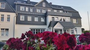 A large, multi-story building with a prominent entrance and a sign indicating it is a hotel. - Hotel Nuhnetal (Winterberg)