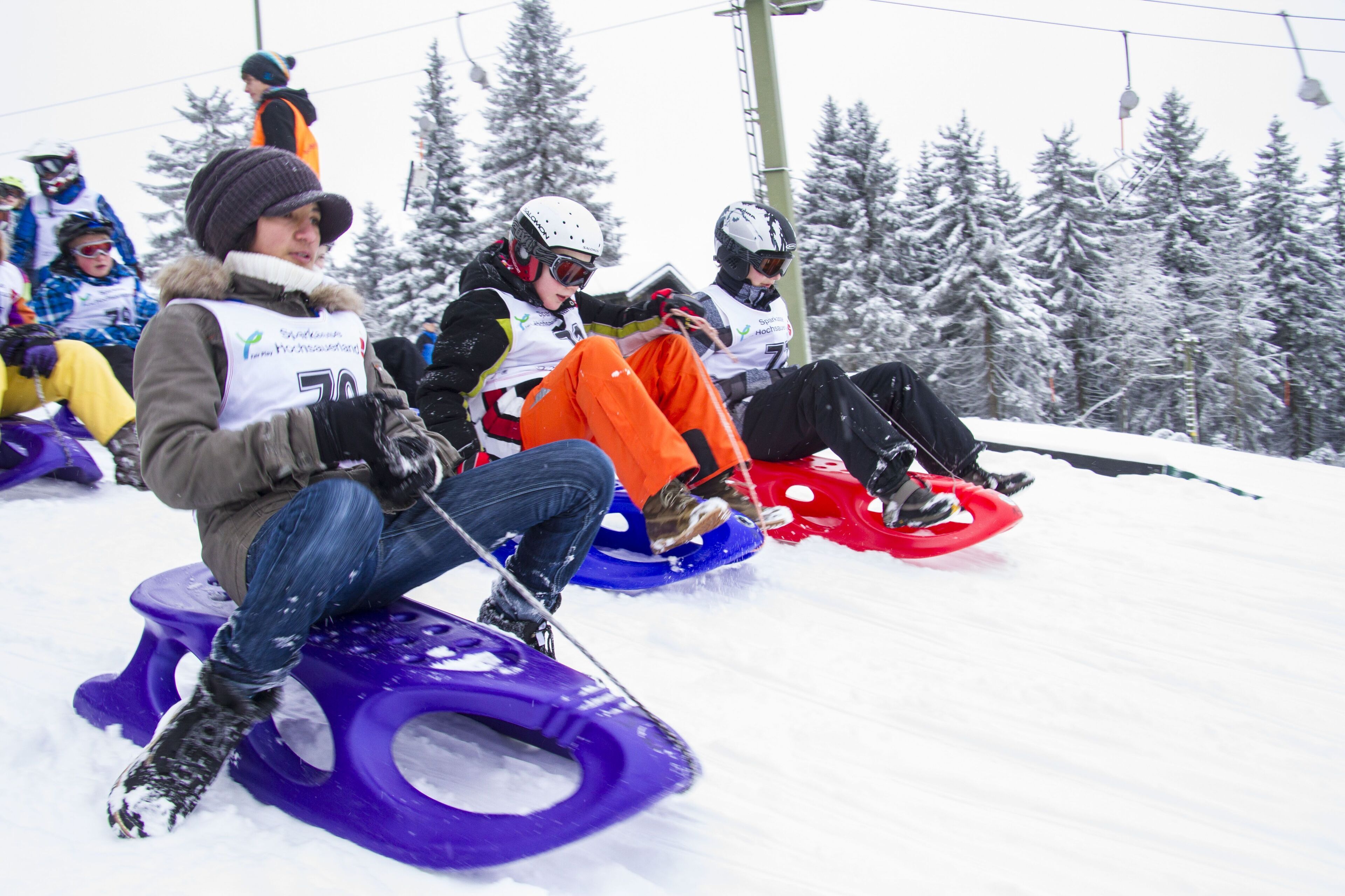 People sledding on snow tubes at a ski resort.
